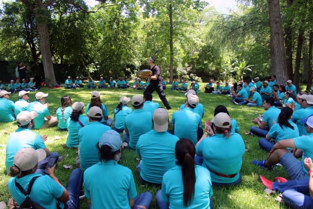 Colaborador de ALYAX sonriendo mientras participa en una dinámica grupal al aire libre, transmitiendo entusiasmo y energía