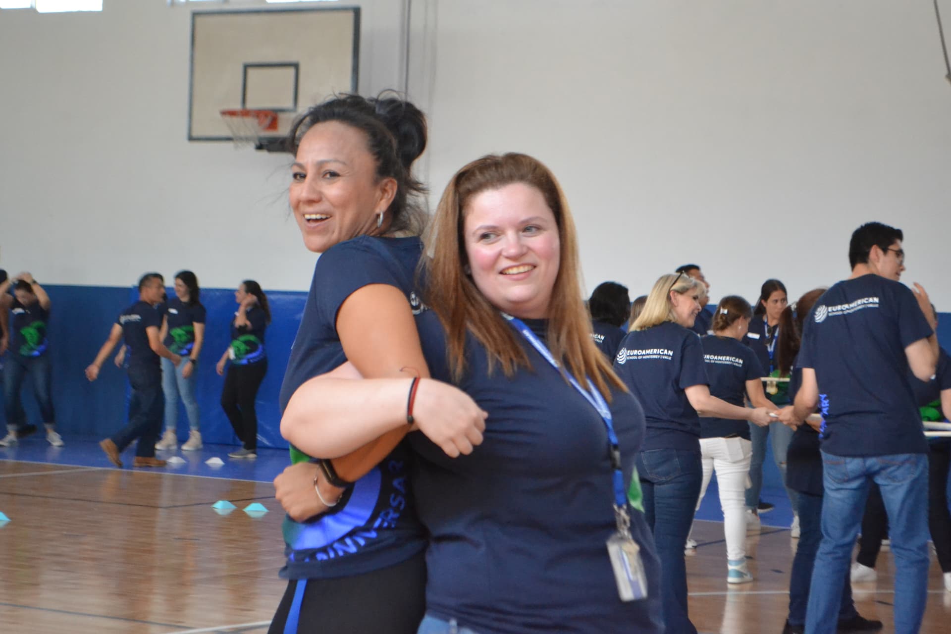 Participantes de ALYAX sonriendo con camisetas que destacan los valores de la organización, como el liderazgo y la innovación