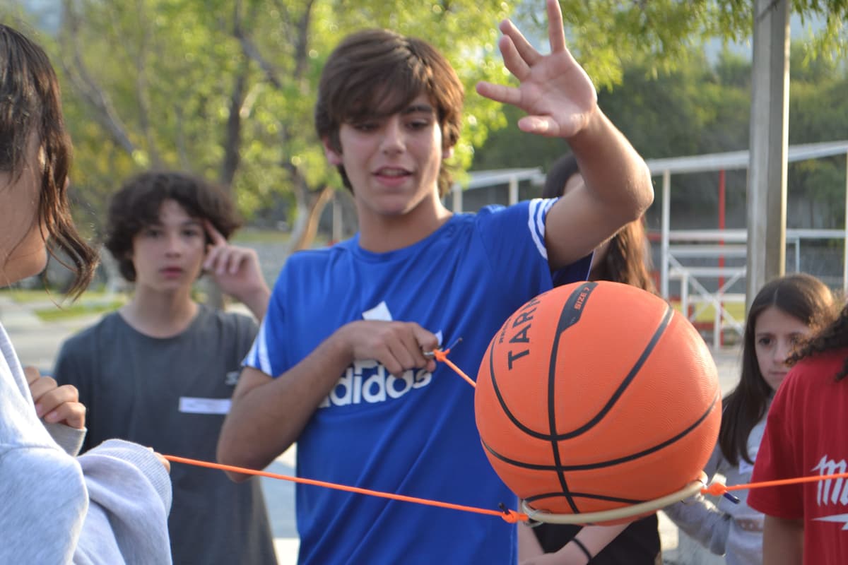 Joven concentrado en un reto grupal, demostrando el desarrollo de habilidades de resolución de problemas