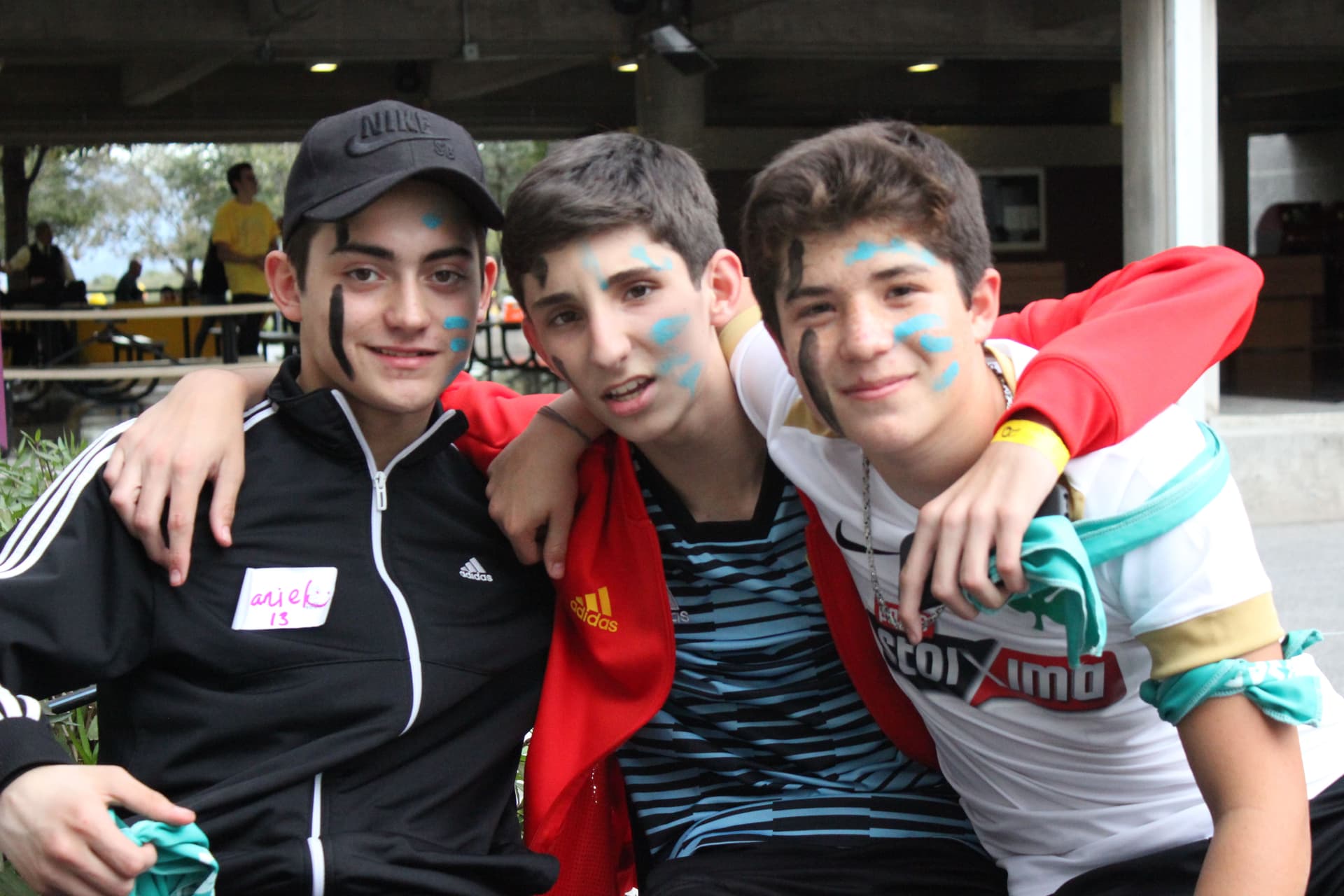 Estudiantes abrazándose y sonriendo después de una actividad, celebrando la unión creada durante el evento