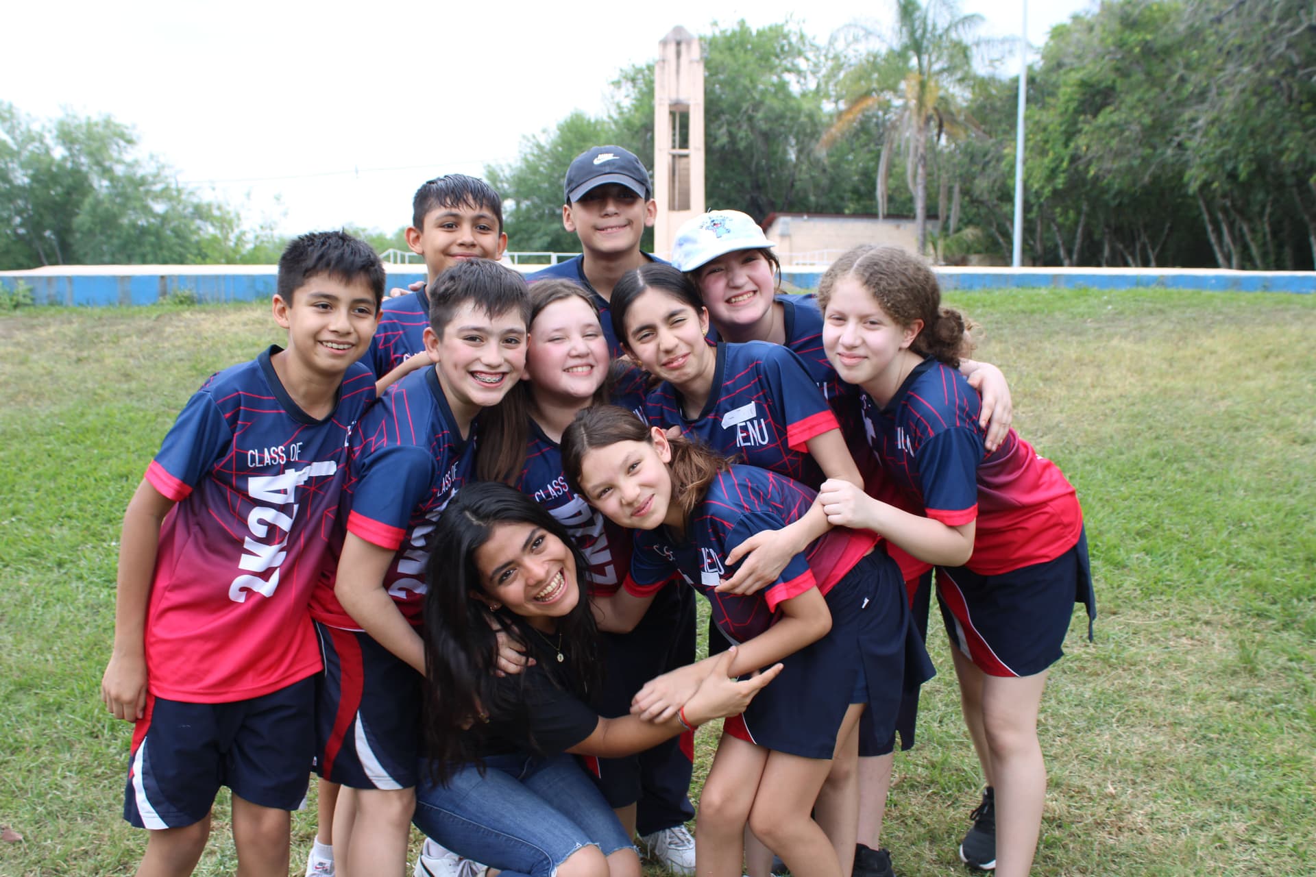 Grupo de alumnos posando juntos para una foto al aire libre, celebrando los lazos creados durante el evento