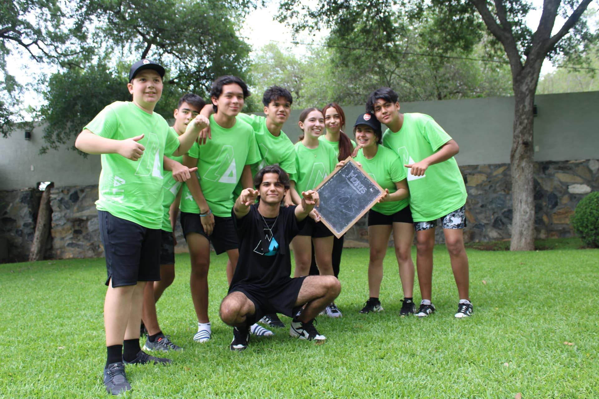 Estudiantes vestidos con camisetas verdes celebrando al final de una actividad, mostrando el éxito de la integración