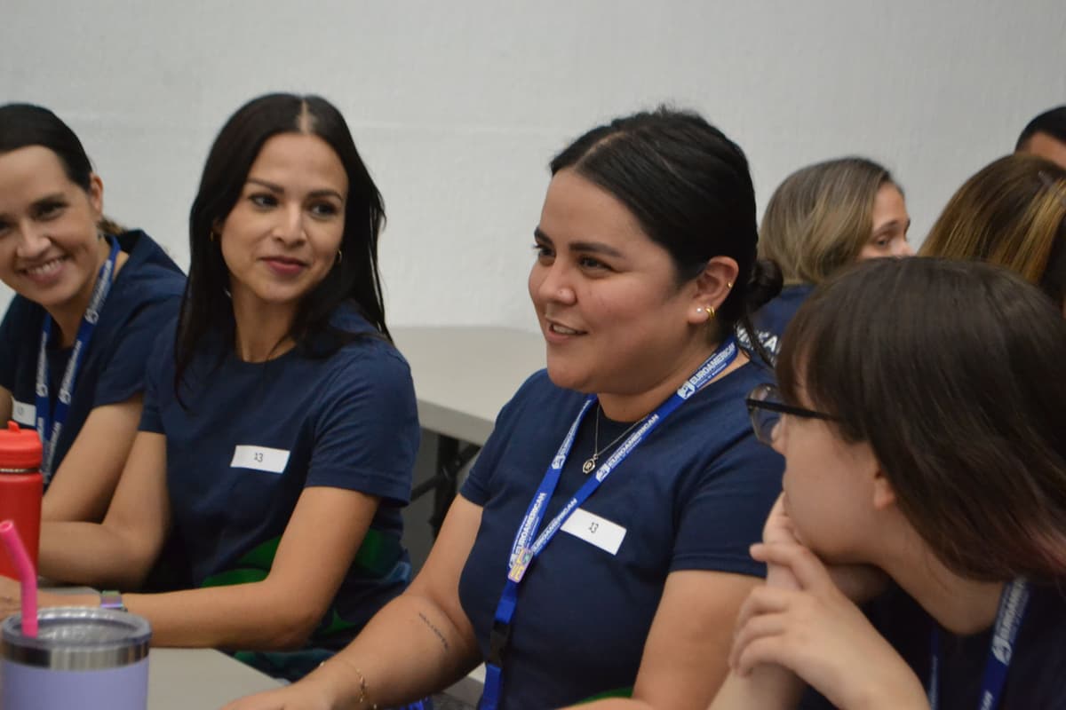 Grupo de maestras sonrientes participando en una actividad colaborativa, reforzando los lazos de compañerismo