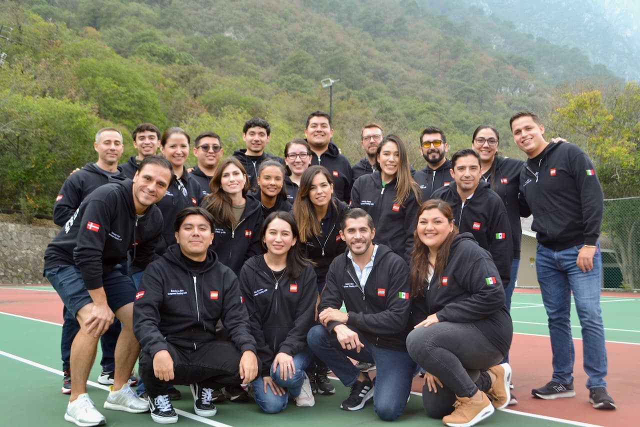 Colaboradores posando juntos, reflejando la unión y el compromiso de un equipo sólido y motivado