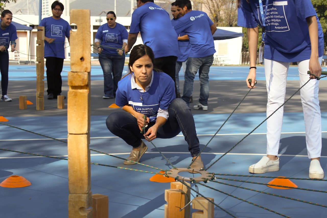 Mujer en cuclillas durante una actividad de integración, simbolizando el equilibrio y la conexión dentro del equipo